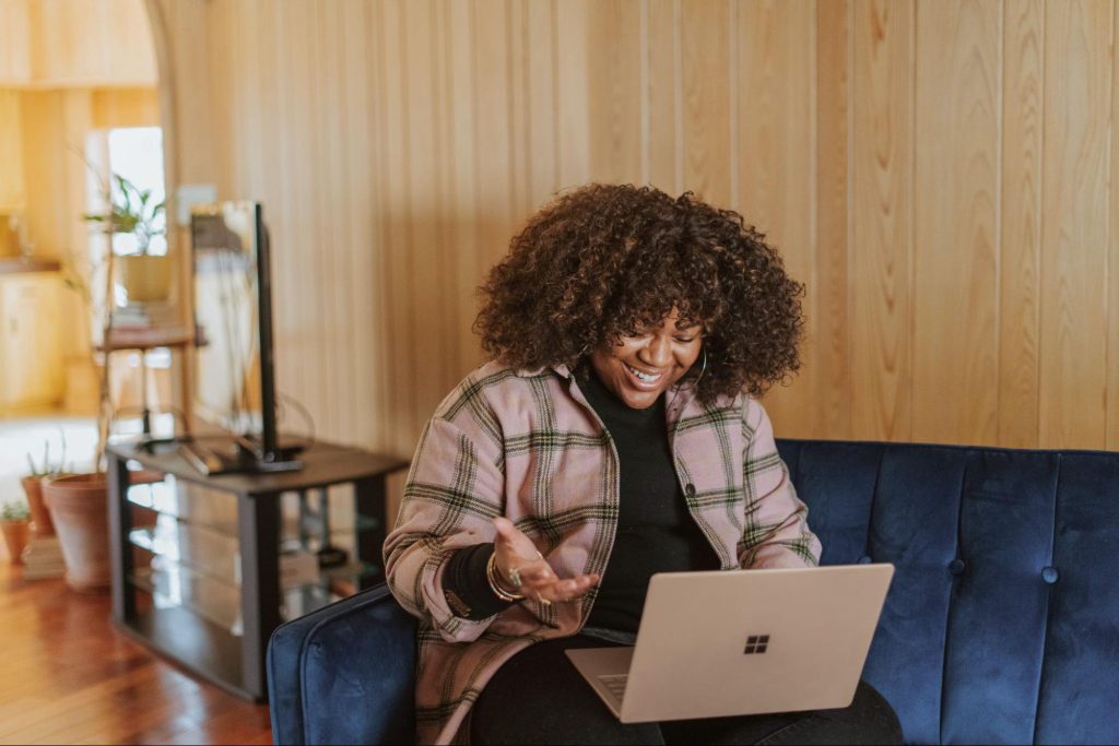 Black woman looking into her laptop and smiling