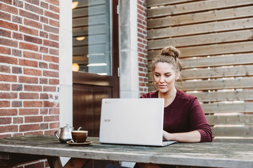 A lady sitting outside looking at a computer