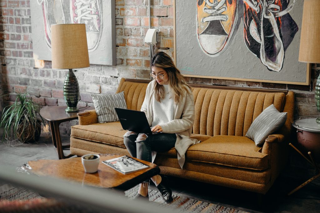 Woman sitting on floor and leaning on couch.