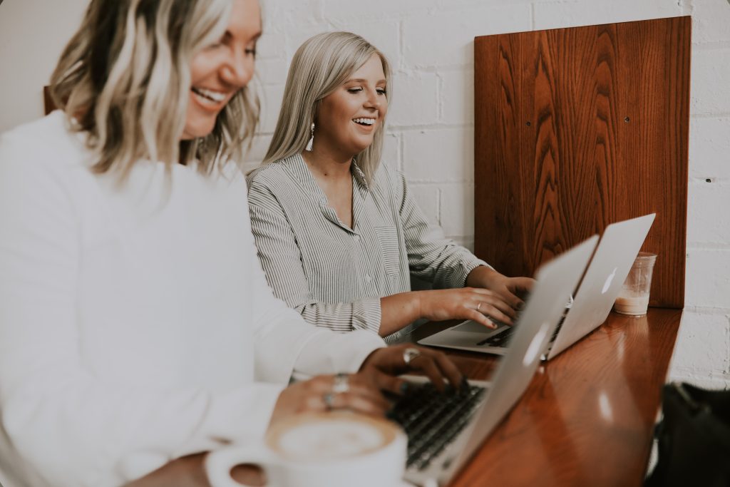 Two ladies operating laptops