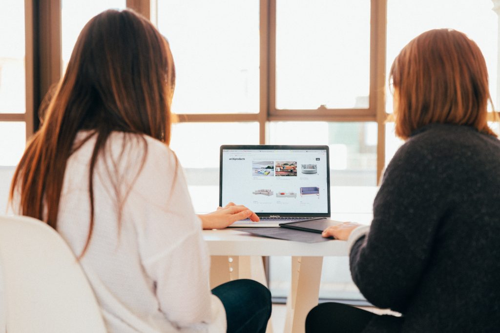 Two women looking into a laptop