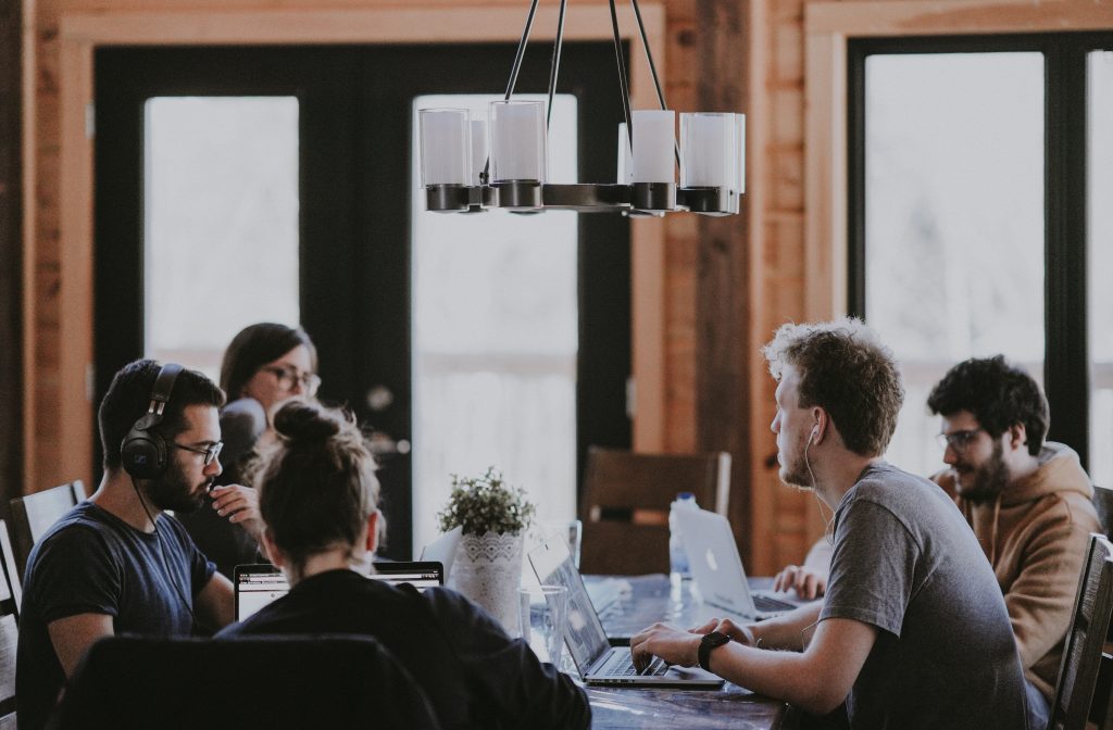 People sitting beside a table in a room.