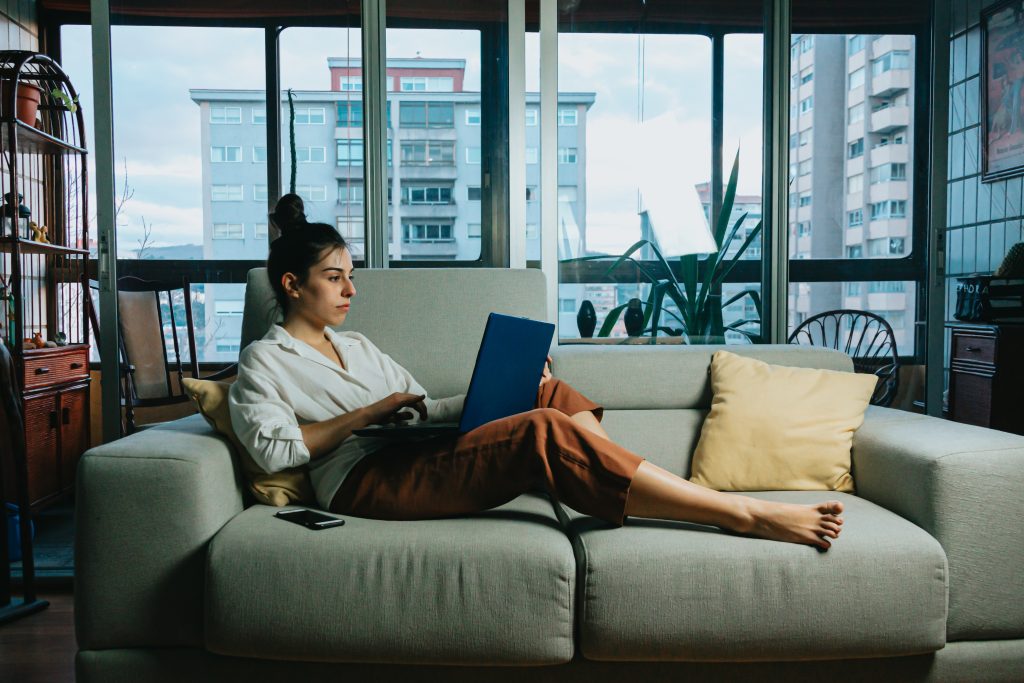 Woman in a white long-sleeve shirt sitting on a couch