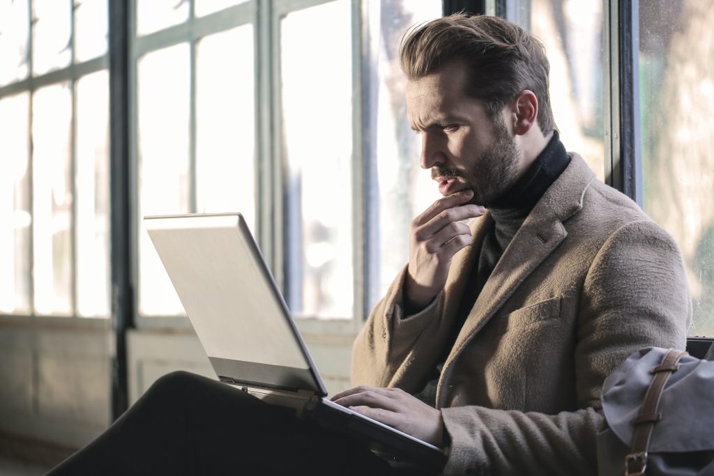 Man holding his chin facing a computer