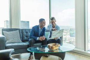 Two men in suit sitting on a sofa