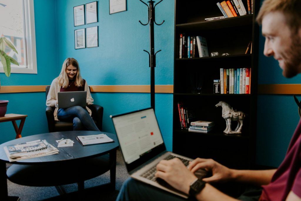 Smiling man using black and grey laptop